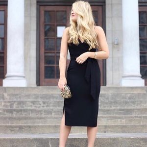 Fitted black midi dress with tie waist.